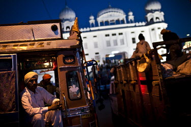 A man sits in the doorway of a bus parked in front of a Sikh temple during the Hola Mohalla Festival. This takes place on the first day of the lunar month of Chet (March/April).