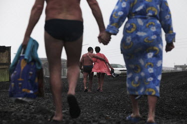 Couples return to their cars after swimming in the river in Norilsk, a resource-rich city in Siberia above the Arctic Circle.