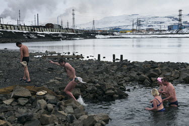 Men and women get out of the river after a swim in Norilsk, a resource-rich city in Siberia above the Arctic Circle.