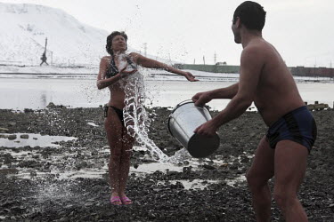A man splashes a woman with water to wash her after she went swimming in the river in Norilsk, a resource-rich city in Siberia above the Arctic Circle.