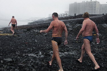 Men walk through sleet as they head towards the river to go swimming in Norilsk, a resource-rich city in Siberia above the Arctic Circle.