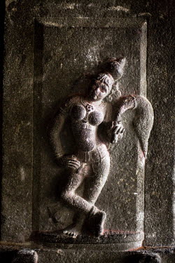 Detail of a stone carving depicting a deity in the Chola style with a fly-whisk at the Murugan temple in Swamimalai.