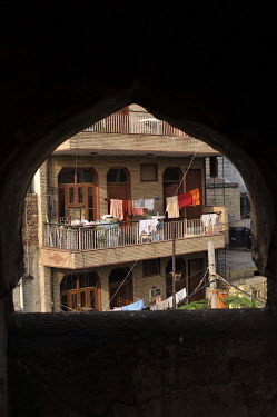 A lower middle class suburban residential block with washing lines, seen through a Moghul-era archway.