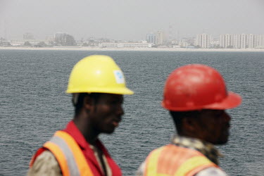 Two workers stand on part of a man made wall some 1.4 kilometres out to sea, off Victoria Island, that is part of an ambitious scheme to reclaim an area of 9000 square metres from the ocean. Eventuall...