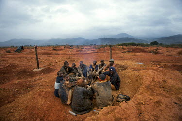 Workers at a small scale gold mine warming themselves around a fire. Thousands of Zimbabweans have crossed into neighbouring Mozambique in search of work, and many have turned to gold mining.