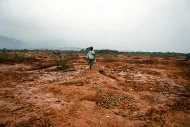 A boy stands in a landscape pock-marked by the workings from small scale gold mines. Thousands of Zimbabweans have crossed into neighbouring Mozambique in search of work, and many have turned to gold...