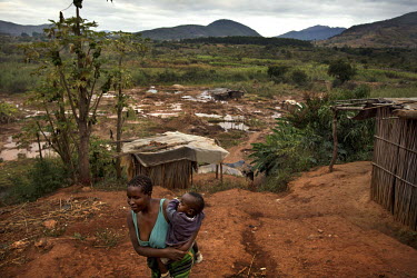 A woman and child in a makeshift village that has grown up close to the site of a small scale gold mine. Thousands of Zimbabweans have crossed into neighbouring Mozambique in search of work, and many...