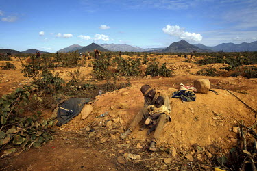 A father and child living on the site of a small scale gold mine. Thousands of Zimbabweans have crossed into neighbouring Mozambique in search of work, and many have turned to gold mining.