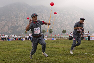 Competitors dressed in PLA (People's Liberation Army) revolutionary era outfits hop in the 'One Legged Race' event at the Red Games. Held in Junan County, this sporting event is a nostalgic tribute to...