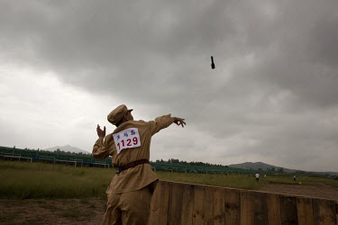 A competitor dressed in a PLA (People's Liberation Army) revolutionary era outfit throws dummy hand grenades in the '40m Grenade Toss' event at the Red Games. Held in Junan County, this sporting event...