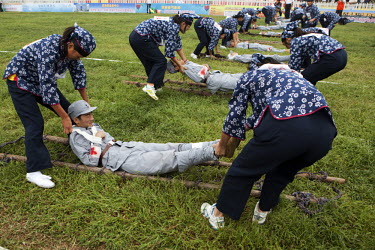 Female competitors dressed as revolutionary volunteers pick up 'wounded soldiers' from the 'battlefield' in the 'Rescue the Wounded Soldier' event of the Red Games. Held in Junan County, this sporting...