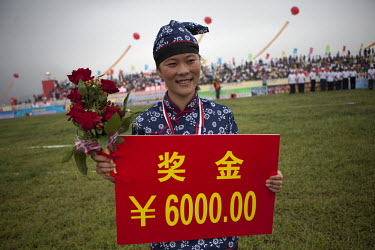 A female competitor dressed as a revolutionary volunteer holds her winners cheque at the Red Games. Held in Junan County, this sporting event is a nostalgic tribute to the communist era.