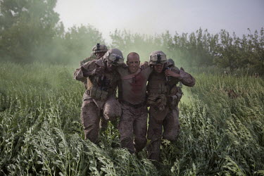 US marines carry a wounded comrade who was shot in the neck onto a Medevac helicopter near Marja.