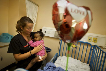 German medical intern Effi Eisele holds a young patient at Tygerberg Hospital in Cape Town.