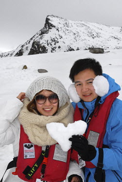 A Chinese tourist couple show a heart they made out of ice at Ytre Norskoya on the island of Spitsbergen on Svalbard.