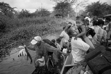 A woman holds her daughter close as passengers, returning to Cacarica, disembark from a boat after crossing the Gulf of Uraba. They are to found a 'Peace Community', a settlement of people who were ex...