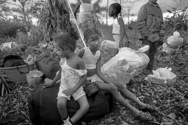 Children wait their family's possessions on the banks of the river Cacarica, as newly arrived passengers disembark from a boat after crossing the Gulf of Uraba. They are to found a 'Peace Community',...