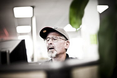 57 year old John sits at a computer looking for a job at the WorkForce One job centre in Hollywood, Florida. He has a part-time job which doesn't include any healthcare benefits, so now he is looking...