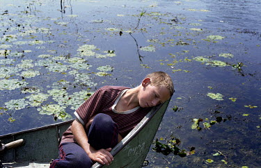 12-year-old Vanea rests in the prow of a fishing boat. He left school to work for a fisherman in the village of Sfistofca. The inhabitants of the Danube Delta live an isolated existance and make a liv...
