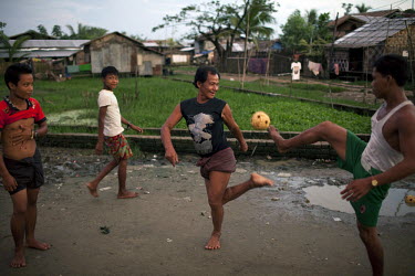 Men play football in Hlaing Thaya slum district of Yangon.