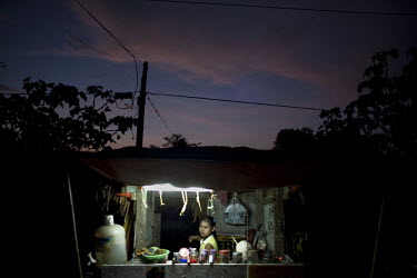 A woman sits at her shop in the Hlaing Thaya slum district of Yangon.