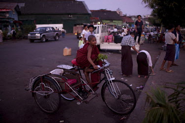 A novice monk waits on a trishaw at the docks in Rangoon (Yangon)