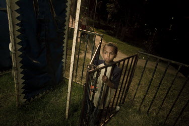 A boy who didn't have the 1000 peso (30 pence) entrance fee waits outside the gate to Marlin Circus. Around a dozen small circuses wander the poorer neighbourhoods around the city of Medellin putting...