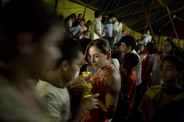 A young woman with mango biche � a green, bitter tasting mango - during the performance interval of Sombrillita Circus in the Alacala neighbourhood of the town of Bello. Around a dozen small circuses...