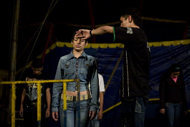 Alfonso feels a girl's forehead to feel her body temperature as members of the audience are put into an hypnotic trance during a performance at the Sombrillita Circus. If the person's body temperature...