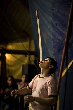 Gustavo balances a machete on his tongue at the Sombrillita Circus. Around a dozen small circuses wander the poorer neighbourhoods around the city of Medellin putting on performances in what can be a...