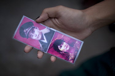A National League of Democracy supporter holds a laminated card of General Aung (left) and his daughters Aung San Suu Kyi (right) outside her party headquarters the day after her release from house ar...