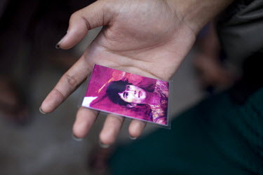 A National League of Democracy supporter holds a laminated card of Aung San Suu Kyi outside her party headquarters the day after her release from house arrest in Rangoon. From 1990 until her release o...