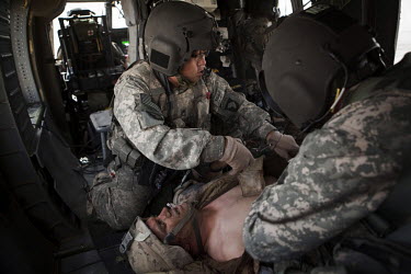 Medics from Charlie Company, Sixth Battalion, 101st Aviation Regiment treat a wounded Canadian soldier onboard a US Army medevac helicopter near Kandahar. He was wounded by shrapnel to his arm.