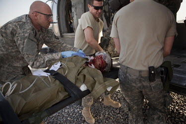 US Army soldiers load a wounded Afghan National Army (ANA) soldier onto a medevac helicopter manned by Charlie Company, Sixth Battalion, 101st Aviation Regiment medics and pilots near Kandahar.