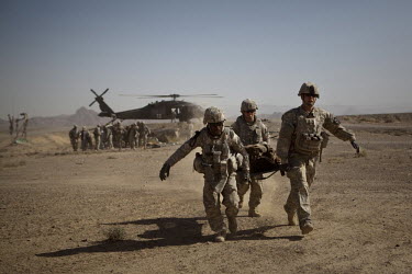 US Army soldiers carry wounded civilians onto Charlie Company, Sixth Battalion, 101st Aviation Regiment medevac helicopters after their vehicle hit an IED (improvised exposive device) near Kandahar.