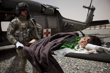 US Army medics from Charlie Company, Sixth Battalion, 101st Aviation Regiment transfer a young girl with a serious head injury onto a medevac helicopter near Kandahar.