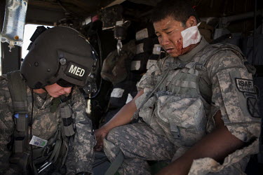 A US Army medic from Charlie Company, Sixth Battalion, 101st Aviation Regiment treats a US Soldier SPC Santisouk Champada, Charley Troop, 1-71 Cav, 1st Brigade Combat Team, 10th Mountain Division who...