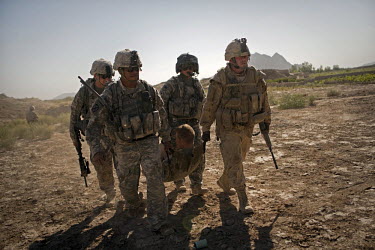 US Army soldiers carry a soldier wounded in an IED (improvised explosive device) blast onto a Charlie Company, Sixth Battalion, 101st Aviation Regiment medevac helicopter near Kandahar.