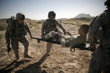 US Army soldiers carry a soldier wounded in an IED (improvised explosive device) blast onto a Charlie Company, Sixth Battalion, 101st Aviation Regiment medevac helicopter near Kandahar.