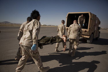 A US Army soldier wounded in an IED (improvised explosive device) blast is loaded into a waiting ambulance at Kandahar airfield.