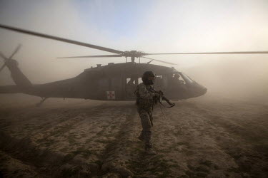 A US Army crew chief secures the landing zone after a medevac helicopter from Charlie Company, Sixth Battalion, 101st Aviation Regiment landed in the middle of a firefight to evacuate wounded US soldi...