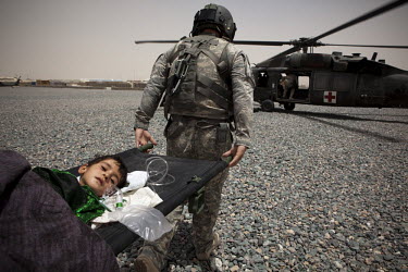 US Army medics from Charlie Company, Sixth Battalion, 101st Aviation Regiment transfer a young girl with a serious head injury onto a medevac helicopter near Kandahar.