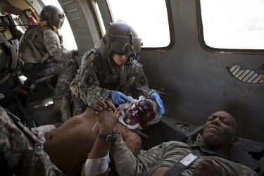 Two US Army soldiers wounded in an IED (improvised explosive device) blast console each other as they are treated on board a medevac helicopter from Charlie Company, Sixth Battalion, 101st Aviation Re...