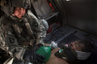 An Afghan National Army (ANA) soldier is treated by US Army medics on board a medevac helicopter from Charlie Company, Sixth Battalion, 101st Aviation Regiment after his vehicle hit an IED (improvised...