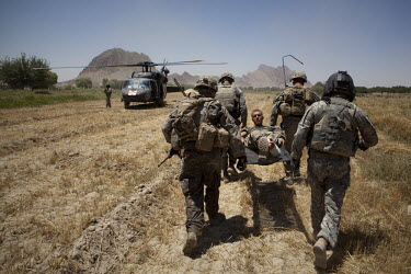 US Army soldiers carry an injured soldier onto a waiting medevac helicopter from Charlie Company, Sixth Battalion, 101st Aviation Regiment near Kandahar.