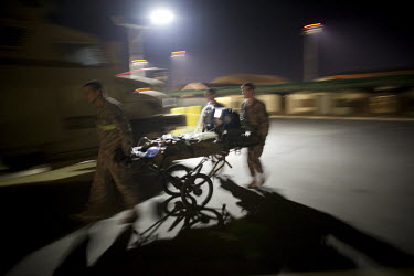 Hospital staff rush a patient from the US Army medevac helicopter landing pad into Bagram's SSG Heath N. Craig Joint Theatre Hospital.