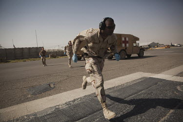 US Navy ambulance drivers run to unload a wounded patient from a US Army medevac helicopter at Kandahar airfield.