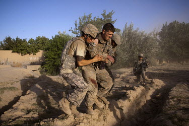 US Army soldiers help a wounded comrade onto a waiting medevac helicopter from Charlie Company, Sixth Battalion, 101st Aviation Regiment in the middle of a firefight near Kandahar. The wounded soldier...