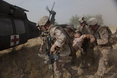 US Marines load a wounded comrade onto a US Army medevac helicopter near Marja.