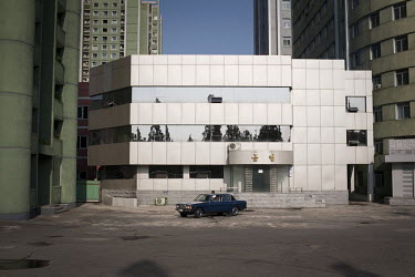 A car is parked outisde a new building in central Pyongyang.